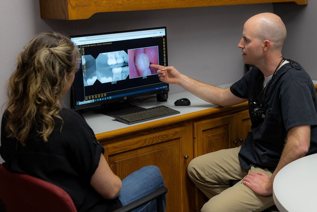 028A7655 Dentist discussing treatment with a parent.